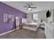 Bedroom with purple accent wall, carpet floor, and a ceiling fan at 8995 Croquet Ct, Champions Gate, FL 33896