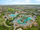 Stunning aerial perspective of community pool area, featuring multiple pools, lounging areas, and lush landscaping at 8995 Croquet Ct, Champions Gate, FL 33896