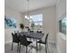 Bright dining room with large window, modern chandelier, and seating for six at 8995 Croquet Ct, Champions Gate, FL 33896