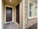 Close up of front entrance with double doors, stone accents, and a neutral color scheme at 8995 Croquet Ct, Champions Gate, FL 33896