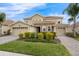 Charming two-story home with a two-car garage, brick driveway, stone accents, and well-manicured landscaping at 8995 Croquet Ct, Champions Gate, FL 33896