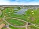 Scenic aerial view of a sprawling golf course with meticulously groomed greens and tranquil water features at 8995 Croquet Ct, Champions Gate, FL 33896