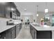 Well-lit kitchen with stainless steel appliances and island with view to dining room at 8995 Croquet Ct, Champions Gate, FL 33896