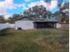 View of the backyard and the back of house showing the exterior wall, porch, and solar panels at 9436 Montello Dr, Orlando, FL 32817