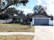 Charming single-story home with a well-maintained lawn and a classic design, featuring an attached garage and mature landscaping at 9436 Montello Dr, Orlando, FL 32817