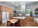 Bright kitchen featuring stone walls, custom wood cabinets, a white marble island, and modern lighting at 105 Pine Street, Windermere, FL 34786