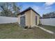 Yellow backyard shed featuring a gray door and trim, surrounded by green grass at 112 Lake Butler Ave, Haines City, FL 33844