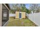 Backyard shed featuring a blue door surrounded by a white privacy fence at 112 Lake Butler Ave, Haines City, FL 33844