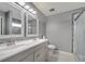 Bathroom with dual sinks, updated lighting fixtures, and glass-enclosed shower at 112 Lake Butler Ave, Haines City, FL 33844
