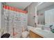 Compact bathroom with a vanity, toilet, and shower featuring a decorative curtain at 112 Lake Butler Ave, Haines City, FL 33844