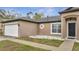 Close up of a charming one-story home with a two-car garage and manicured lawn at 112 Lake Butler Ave, Haines City, FL 33844