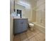 Well-lit bathroom featuring a gray vanity with black hardware, framed mirror, and a shower-tub combo at 13900 Corrine Key Pl, Orlando, FL 32824