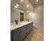 Bathroom featuring a double sink vanity with gray cabinets, a large mirror, and tile flooring at 13900 Corrine Key Pl, Orlando, FL 32824