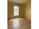 Bedroom with tiled floors and a sunlit window at 13900 Corrine Key Pl, Orlando, FL 32824