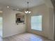 Dining room with tile flooring, a modern chandelier, and a view into the adjacent kitchen at 13900 Corrine Key Pl, Orlando, FL 32824