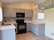 Kitchen featuring gray cabinets, black appliances, mosaic tile backsplash, and tile floors at 13900 Corrine Key Pl, Orlando, FL 32824