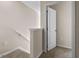Carpeted hallway featuring a half wall next to the staircase and a white door at 1430 Ironbark Bnd, Davenport, FL 33837