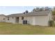 Rear exterior view of a single-story home with sliding glass doors, A/C unit, and chain-link fence at 15003 Sw 43Rd Terrace Rd, Ocala, FL 34473