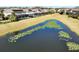 Aerial view of community featuring a pond and well-maintained lawns at 15165 Heron Hideaway Cir, Winter Garden, FL 34787