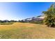 Manicured backyard featuring a pond, a grassy area, and screened-in porch at 15165 Heron Hideaway Cir, Winter Garden, FL 34787
