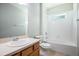 Well-lit bathroom featuring a vanity, toilet, and a tub with shower and white tile surround at 15165 Heron Hideaway Cir, Winter Garden, FL 34787