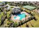 Aerial view of the community pool and clubhouse surrounded by lush landscaping and palm trees at 15165 Heron Hideaway Cir, Winter Garden, FL 34787