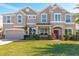 Stately home with a manicured lawn, brick-paved driveway, attached two-car garage, and neatly trimmed landscaping at 15165 Heron Hideaway Cir, Winter Garden, FL 34787
