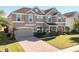 Charming two-story home featuring a well-manicured lawn and brick driveway leading to an attached two-car garage at 15165 Heron Hideaway Cir, Winter Garden, FL 34787