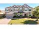 Charming two-story home featuring a well-manicured lawn and brick driveway leading to an attached two-car garage at 15165 Heron Hideaway Cir, Winter Garden, FL 34787