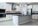 Stylish kitchen with sleek white cabinets, stainless steel appliances, a central island, and tiled backsplash at 15165 Heron Hideaway Cir, Winter Garden, FL 34787