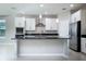 Updated kitchen featuring white cabinets, stainless steel appliances, granite countertops, and a central island at 15165 Heron Hideaway Cir, Winter Garden, FL 34787