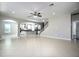 Open-concept living room with tile floors, ceiling fan, and view of the kitchen and staircase at 15165 Heron Hideaway Cir, Winter Garden, FL 34787