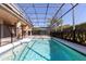 A beautiful screened pool area featuring tile accents and a black safety fence at 15165 Heron Hideaway Cir, Winter Garden, FL 34787
