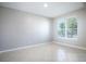 Bright, neutral room with tile flooring, a large window offering natural light, and baseboard trim at 15165 Heron Hideaway Cir, Winter Garden, FL 34787
