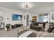 Open-concept living room with tile floors, TV, modern lighting and access to the kitchen at 15914 Moonlight Bay St, Winter Garden, FL 34787