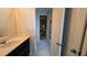 Well-lit bathroom featuring a single vanity with black cabinets and a doorway leading to another room at 1731 Caribbean View Ter, Kissimmee, FL 34747