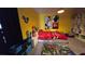 Vibrant bedroom featuring bright yellow walls, playful decor, and carpeted flooring at 1731 Caribbean View Ter, Kissimmee, FL 34747