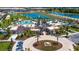 An aerial view shows the community center and resort-style pool surrounded by palm trees and greenery at 1731 Caribbean View Ter, Kissimmee, FL 34747