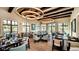Elegant dining room with modern lighting, large windows, dark wood tables, and comfortable chairs for a delightful dining experience at 1731 Caribbean View Ter, Kissimmee, FL 34747