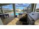 Outdoor kitchen with a stainless steel grill, sink and fridge overlooking a pool with a jacuzzi at 1731 Caribbean View Ter, Kissimmee, FL 34747