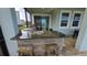 Covered outdoor kitchen with granite counters, stainless steel grill, sink, and bar seating at 1731 Caribbean View Ter, Kissimmee, FL 34747