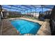 Sparkling pool with jacuzzi surrounded by lounge chairs, and enclosed by black mesh pool screen at 1731 Caribbean View Ter, Kissimmee, FL 34747