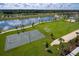 Aerial view of community recreation fields, including a basketball court, soccer field, and walking path by the lake at 1731 Caribbean View Ter, Kissimmee, FL 34747