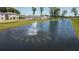 Pond with a water fountain on a sunny day in a community with newer houses at 179 River Front Way, Edgewater, FL 32141