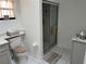 Well-lit bathroom with a shower and glass door, tiled floor and a white cabinet at 2013 Bates Ave, Eustis, FL 32726