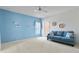 Living room featuring blue accent wall, neutral carpet flooring, ceiling fan, and comfortable sofa at 2312 Twickingham Ct, Clermont, FL 34711