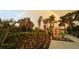 Picturesque backyard with landscaped garden, trees, and a vivid double rainbow in the background at 2369 Palm Park Loop, Clermont, FL 34714