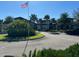 A contemporary clubhouse entrance featuring lush landscaping and an American flag at 2369 Palm Park Loop, Clermont, FL 34714