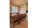 A spacious dining area features a long wooden table with seating for eight and a modern light fixture at 2369 Palm Park Loop, Clermont, FL 34714