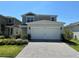 Two-story home with manicured lawn and a two-car garage, featuring gray and white exterior paint at 2369 Palm Park Loop, Clermont, FL 34714